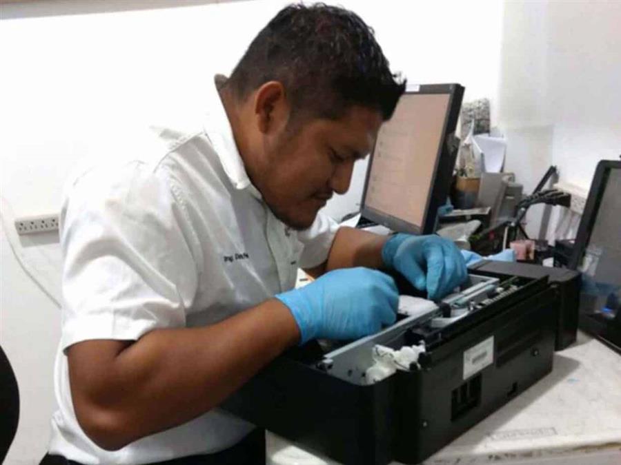Técnico realizando mantenimiento a una impresora