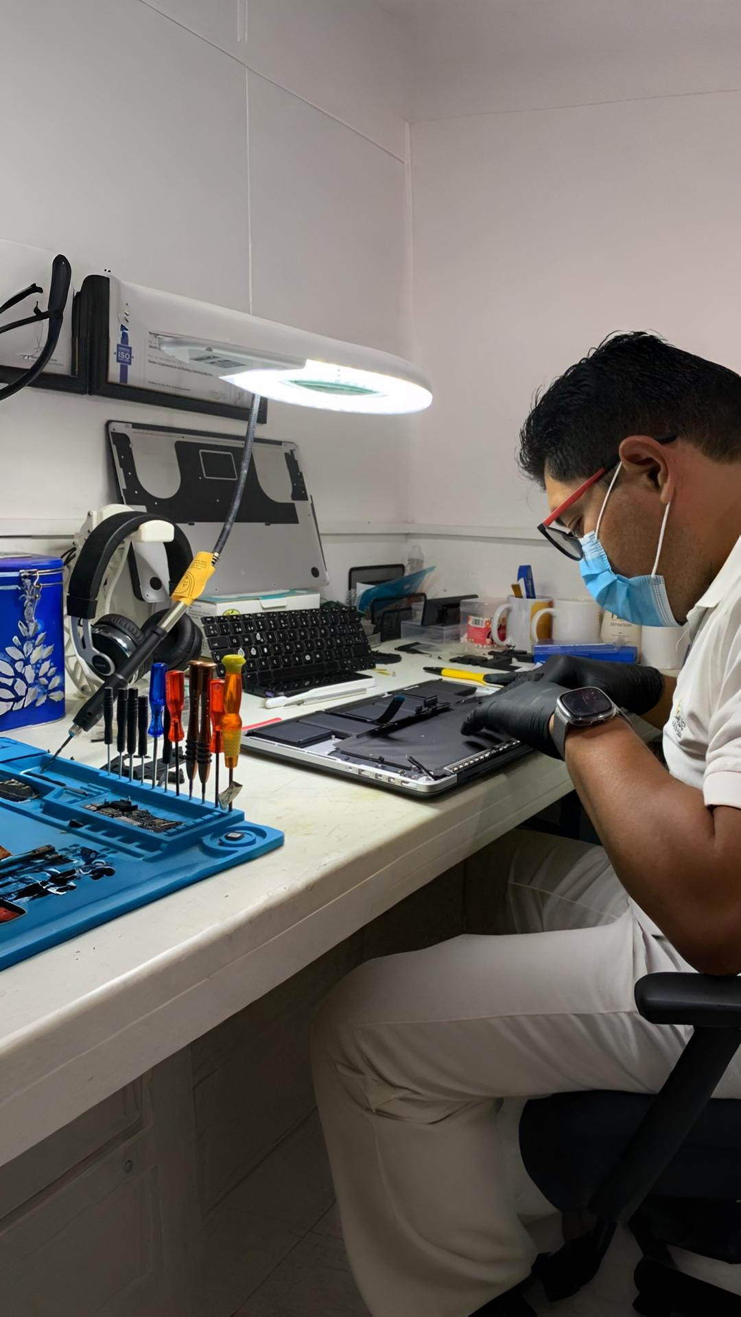 Técnico de Grupo Icarus revisando una laptop en el taller